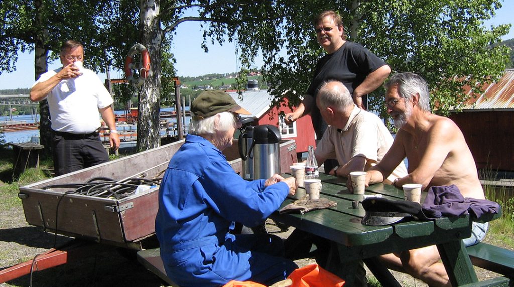 Menn som drikker kaffe rundt et bord.