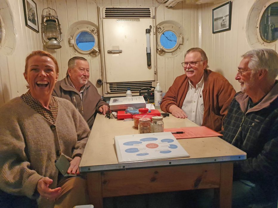 Foto av fire personer rundt et bord i skipsbysse.